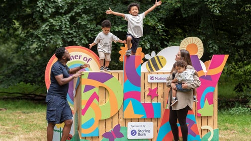 Family climbing on a Summer of Play activity wall at Dunham Massey in Cheshire